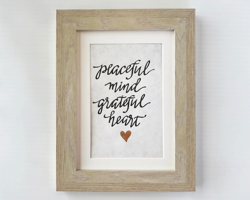 Hand Lettered Calligraphy Quote in black and gold ink, "Peaceful mind Grateful heart"